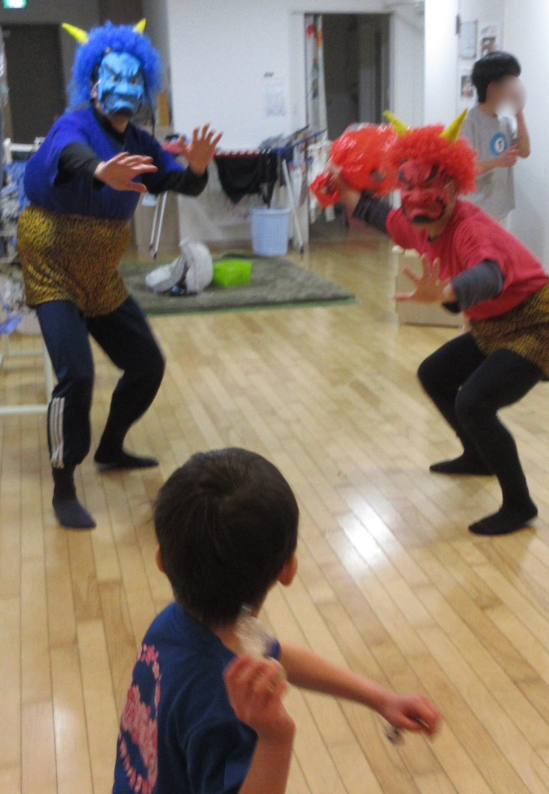 「鬼は外！」と豆をまく子ども